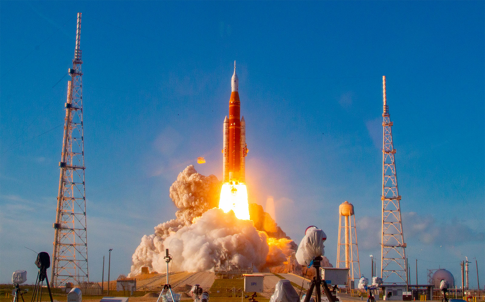 Artemis II launching from the pad, lighting the sky as it ascends.