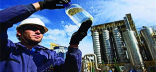Worker holding jar of clear liquid.